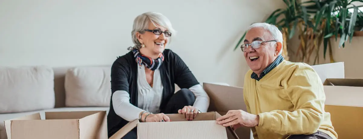 Senior couple packing moving boxes