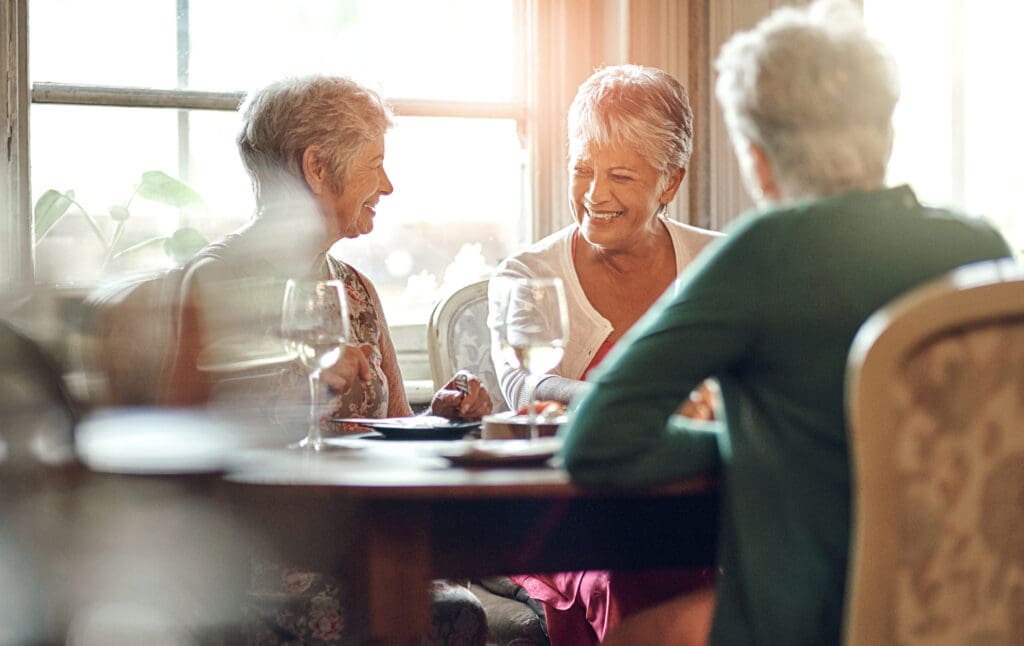 Seniors sitting around a table after discussing signs it's time for Independent Living at Canterbury Woods Gates Circle.
